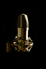 Studio microphone isolated on black background with side lightning