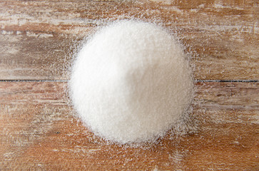 food, junk-food, cooking and unhealthy eating concept - close up of white sugar heap on wooden table