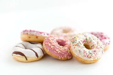 sweet food, junk-food and unhealthy eating concept - close up of glazed donuts on white table