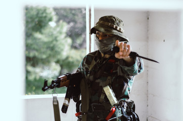 Special forces soldier  looks to the right  point  finger at you looking at camera