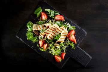 Salad with grilled halumi with strawberries and arugula.