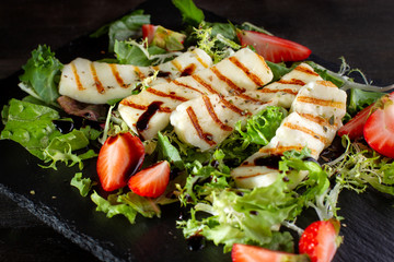 Salad with grilled halumi with strawberries and arugula.
