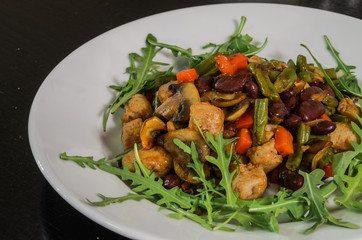 Vegetarian vegetable salad with mushrooms, arugula, carrots, beans and pepper
