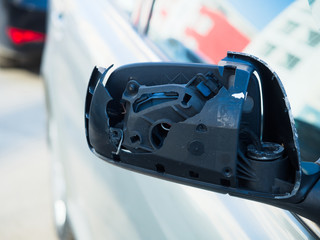 Obraz premium broken side view mirror of car. Car accident. Photo from the front.