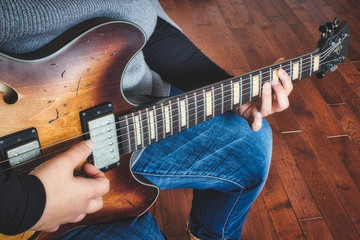 A woman playing an electric semi-hollow guitar  - obrazy, fototapety, plakaty