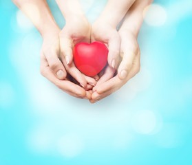 Man and woman holding red heart in hands isolated on white