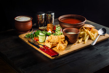 Lunch on a wooden board. Soup, chicken breast, salad and sauce-2.