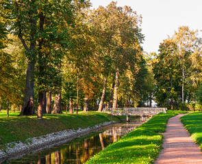 Alley and river on a sunny day in autumn park