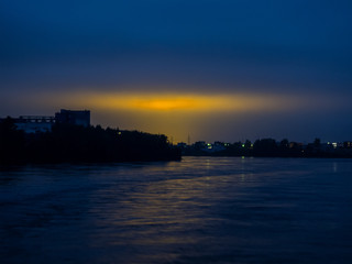 Fototapeta premium Night sky with reflection of the yellow lights of the city