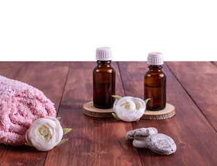 Spa or wellness bottles with oil and a towel, flower, stones