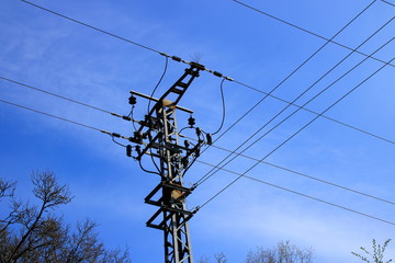 Strommast und Stromkabel vor einem blauen Himmel
