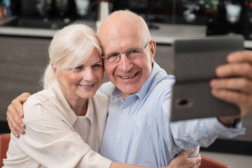 Fototapeta na wymiar Cheerful senior couple taking selfie