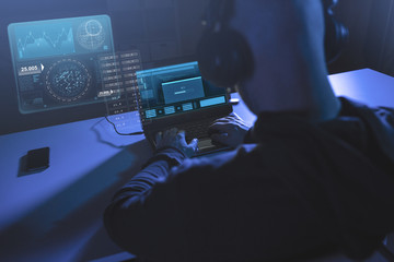 cybercrime, hacking and technology concept - male hacker in headphones with progress loading bar on...