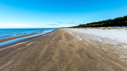 empty sea beach with ice leftovers and no snow