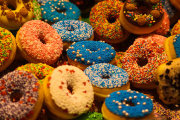 Exhibition of colorful donuts decorated with fancy crumbles in the market hall of Rotterdam, Netherlands
