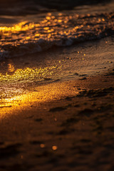 colorful sunset over calm sea beach with dark blue water and dramatic contrasty clouds