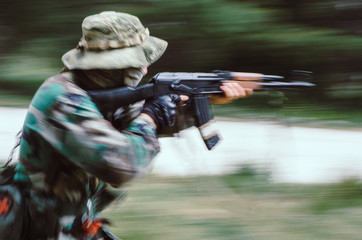 Blurry on motion Special forces soldier holding rifle  aim and run