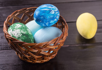 Easter eggs in a basket close up on a wooden background