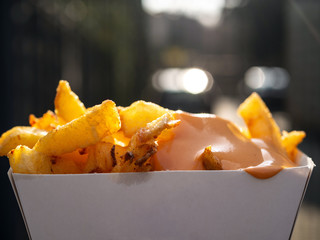 Box of french fries with sauce.