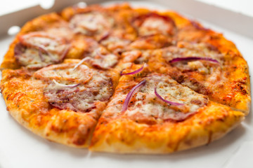 fast food and unhealthy eating concept - close up of sliced takeaway pizza in paper box