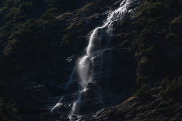 Fototapeta na wymiar Wasserfall in den Alpen im Gegenlicht