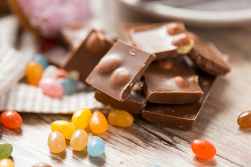 food, sweets and unhealthy eating concept - close up of jelly bean candies and chocolate on table
