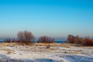 frozen sea beach in winter with low snow coverage