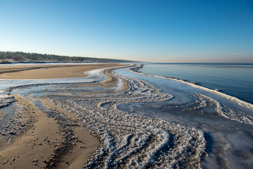 frozen sea beach in winter with low snow coverage