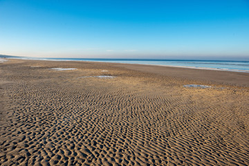 frozen sea beach in winter with low snow coverage