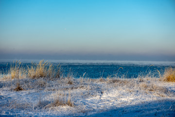 frozen sea beach in winter with low snow coverage