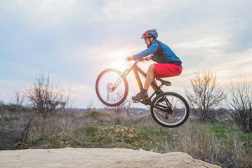 Fototapeta na wymiar Cyclist on a mountain bike performing a jump. Active lifestyle.