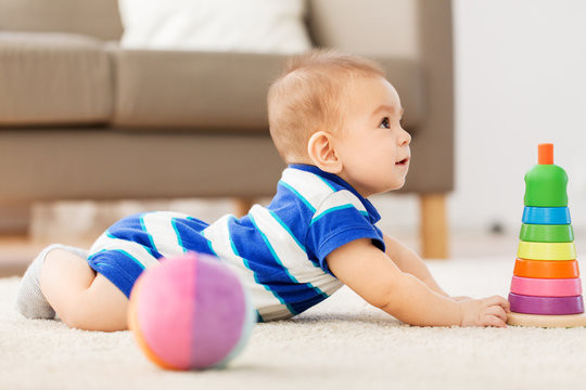 babyhood, childhood and people concept - sweet little asian baby boy playing with toy ball