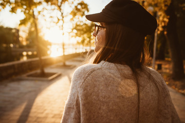 Attractive, young brunette with long hair walking autumn park.