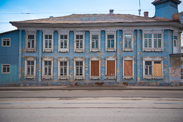 Fototapeta na wymiar old dilapidated wooden building with broken and boarded up windows with shabby paint