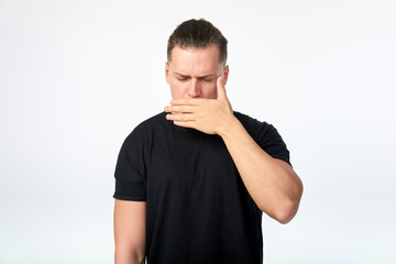 Portrait of scared man covering his mouth with hand. Studio shot on white background.