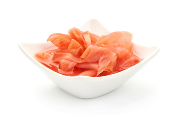 Red pickled ginger in bowl, close-up, isolated on white background