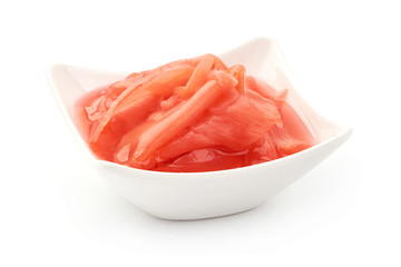 Marinated ginger slices in bowl, close-up, isolated on white background