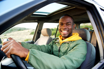 smiling young african american man driving car