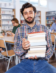 Portrait of adult bearded man with books