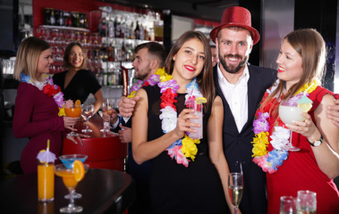 Man and two women on Hawaiian party at nightclub
