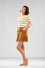 people concept - happy smiling young woman in striped pullover, short skirt and ballet flat shoes...