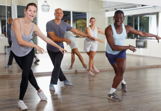 Group of multinational happy adult people enjoying active dance movement