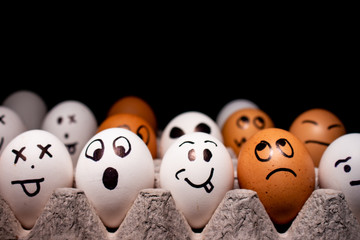 Eggs with funny expressions simulating human faces. Concept of ethnic diversity and moods.