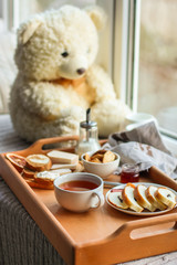 cornflakes, coffee, bread, butter, eggs, jam and other ingredients for breakfast on a dark background. Top view with copy space