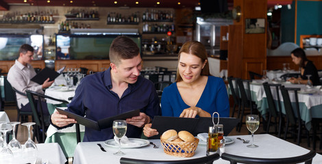 Couple and reading menu in restaurant