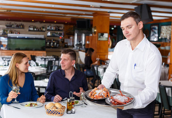 Fototapeta na wymiar Waiter demonstrating tray of lobsters