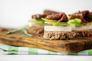 Hearty sandwiches with cheese, avocado and dried tomatoes. Concept for food, healthy food and vegetarians.