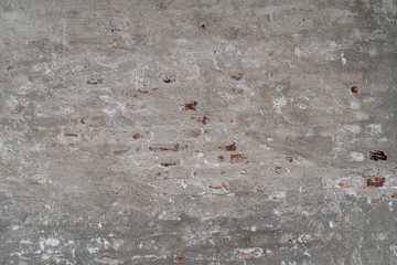 Old gray stone wall with broken plaster as a backdrop