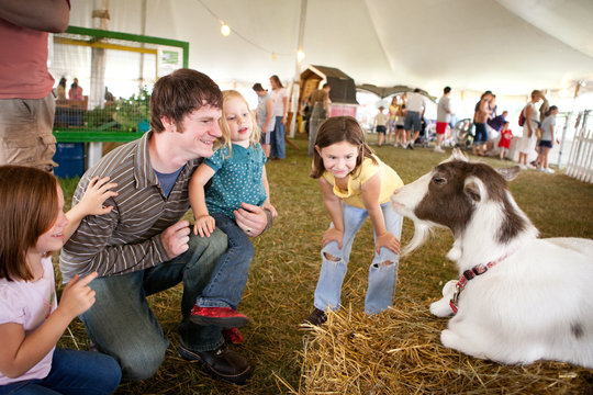 Family Looking at a Goat at Agricultural Fair