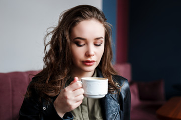 Beautiful young woman holding a cup of coffee